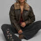 Urban grunge fashion presentation featuring a baggy distressed dark brown leather jacket accented with fur, styled for a vintage winter look.