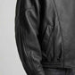 Close-up shot of elasticated ribbed cuffs and premium textured grain on black genuine leather fabric.