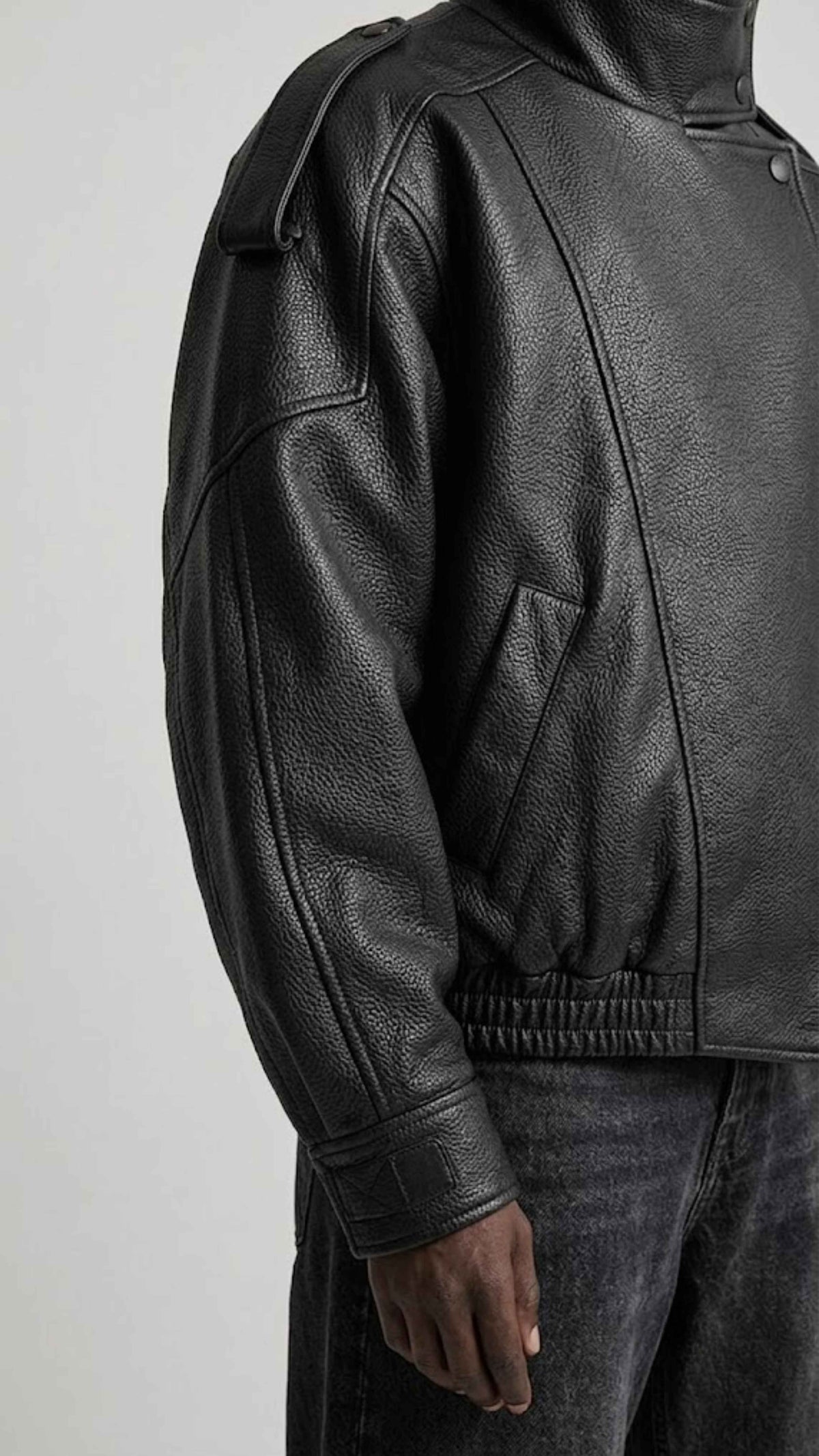 Close-up shot of elasticated ribbed cuffs and premium textured grain on black genuine leather fabric.