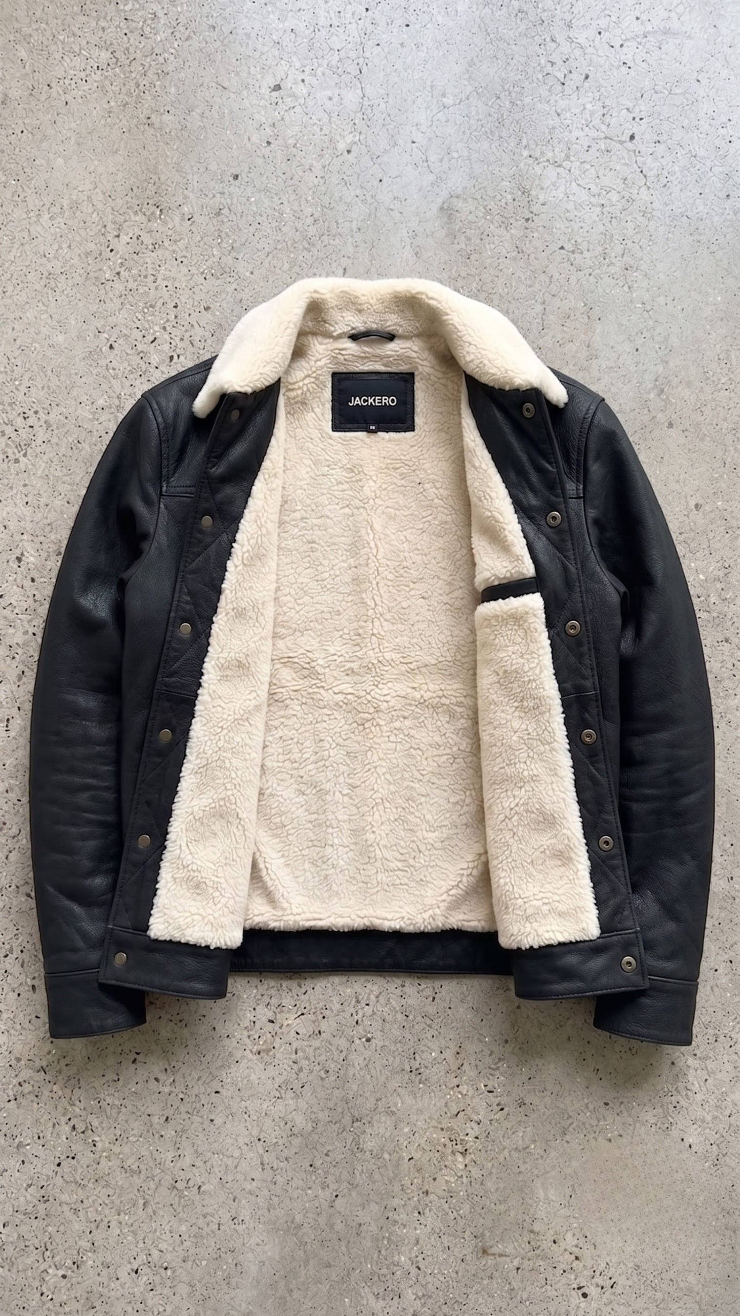 Premium winter fashion lookbook featuring a structured black leather trucker coat with soft cream sherpa lining.