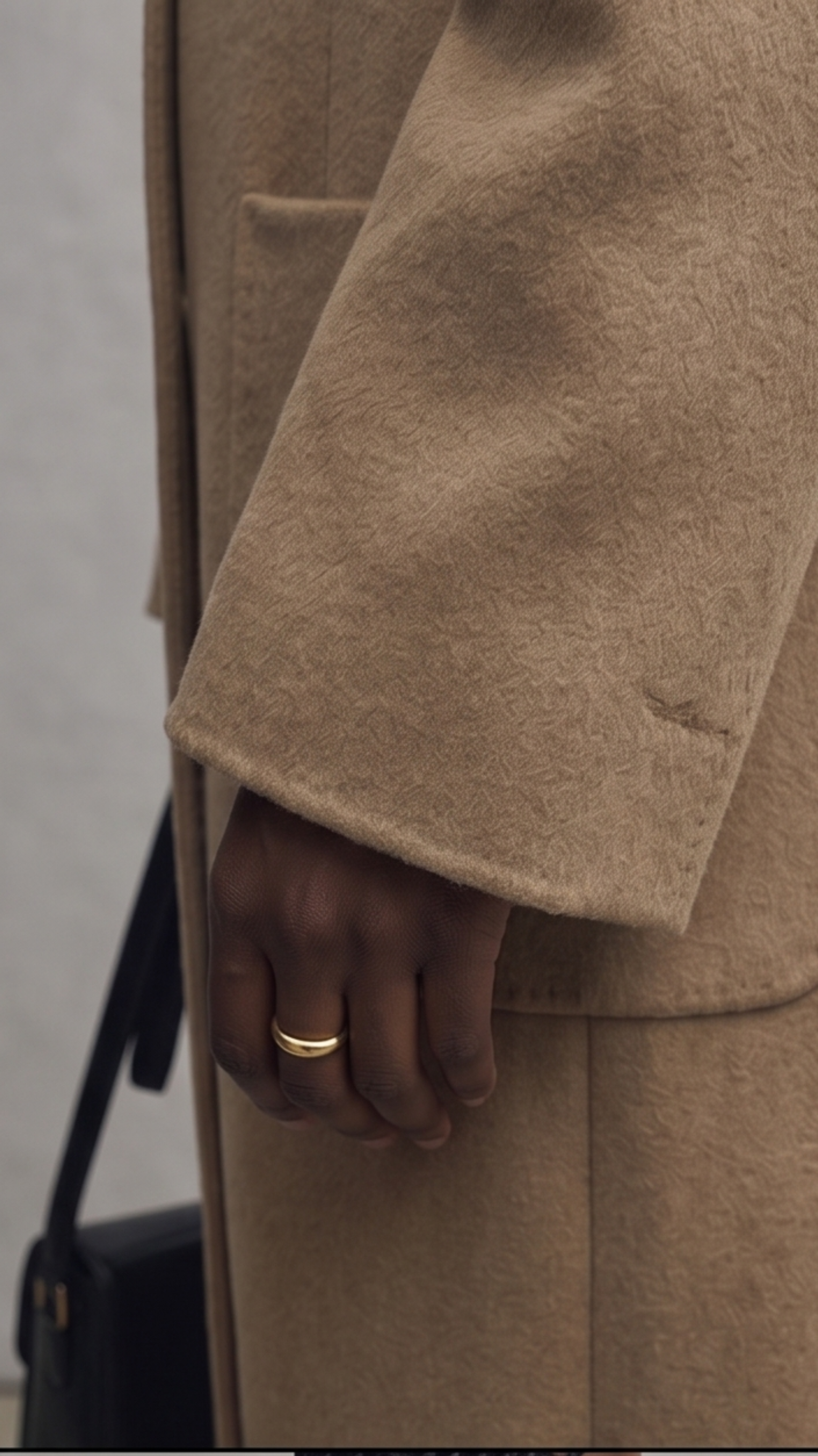 Close-up of a person wearing a beige coat with a blurred background