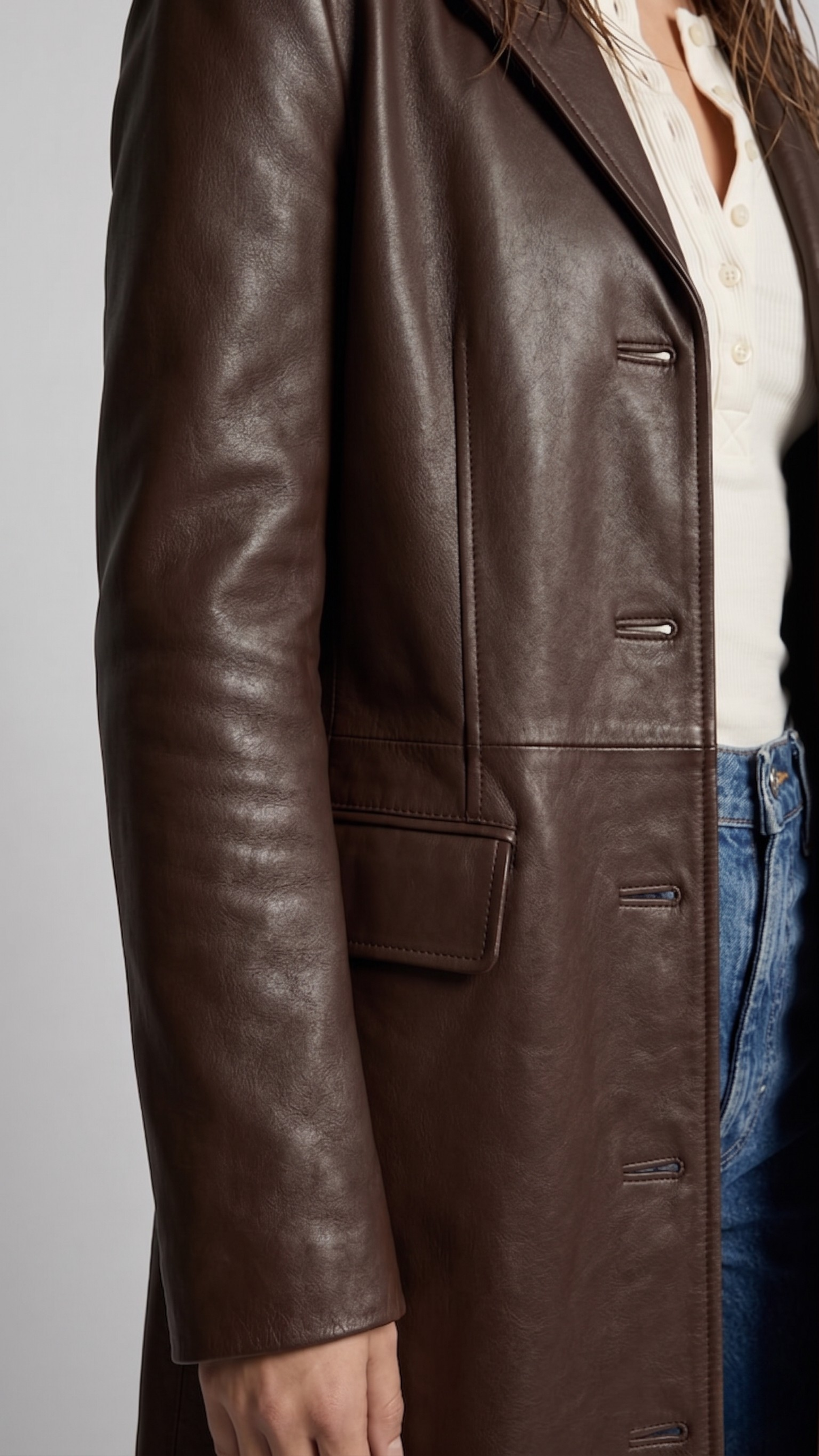 Close-up highlighting the premium grain texture of the dark chocolate leather coat.