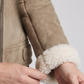Close-up shot showing the fine, velvety texture of beige suede fabric contrasted with plush white fur lining details.