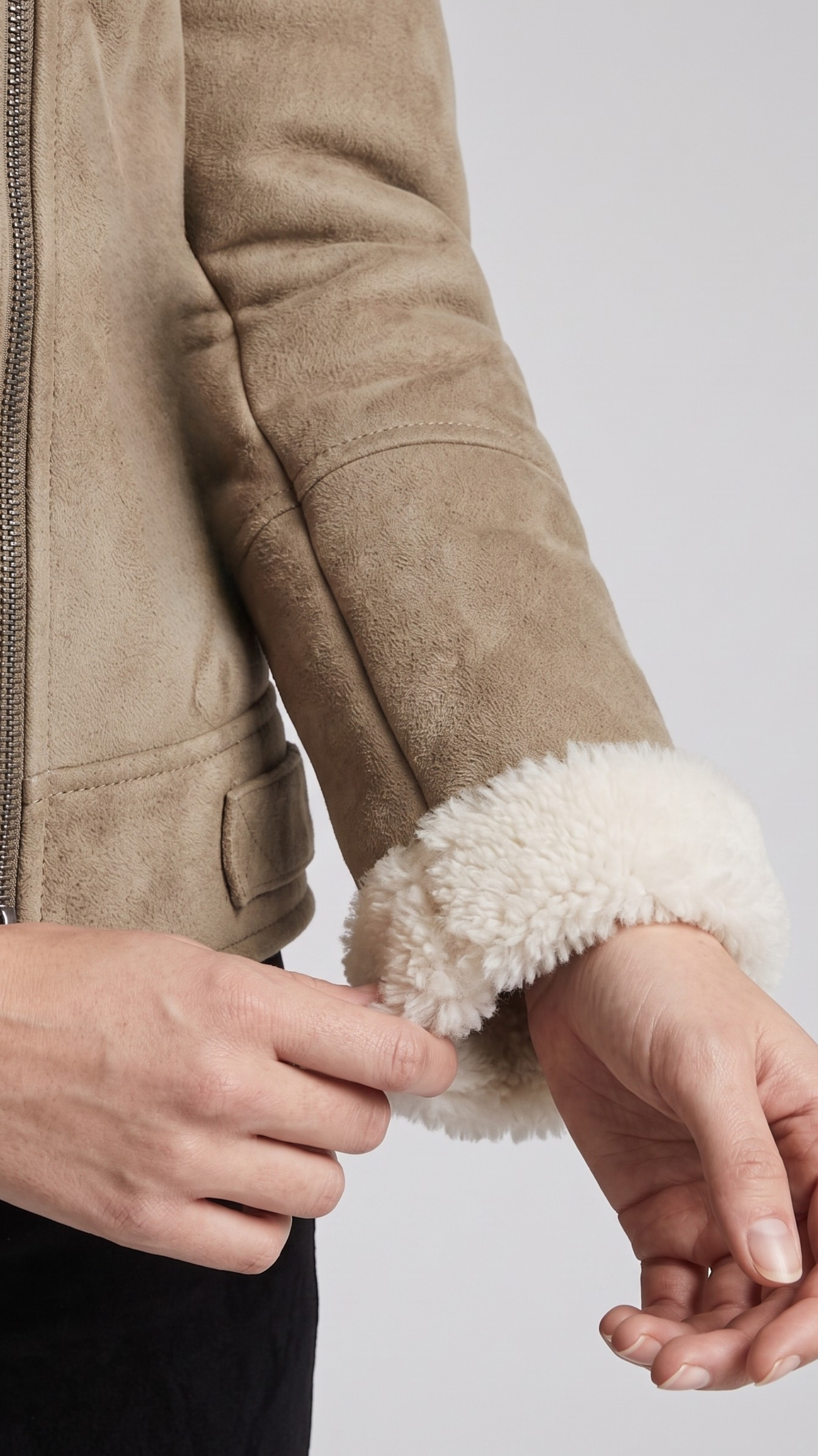 Close-up shot showing the fine, velvety texture of beige suede fabric contrasted with plush white fur lining details.