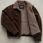 dark brown suede jacket highlighting the premium soft texture, heavy-duty zipper, and warm brown shearling trim.