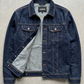 Blue denim jacket on a gray concrete surface