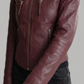 Maroon leather jacket worn by a person on a gray background