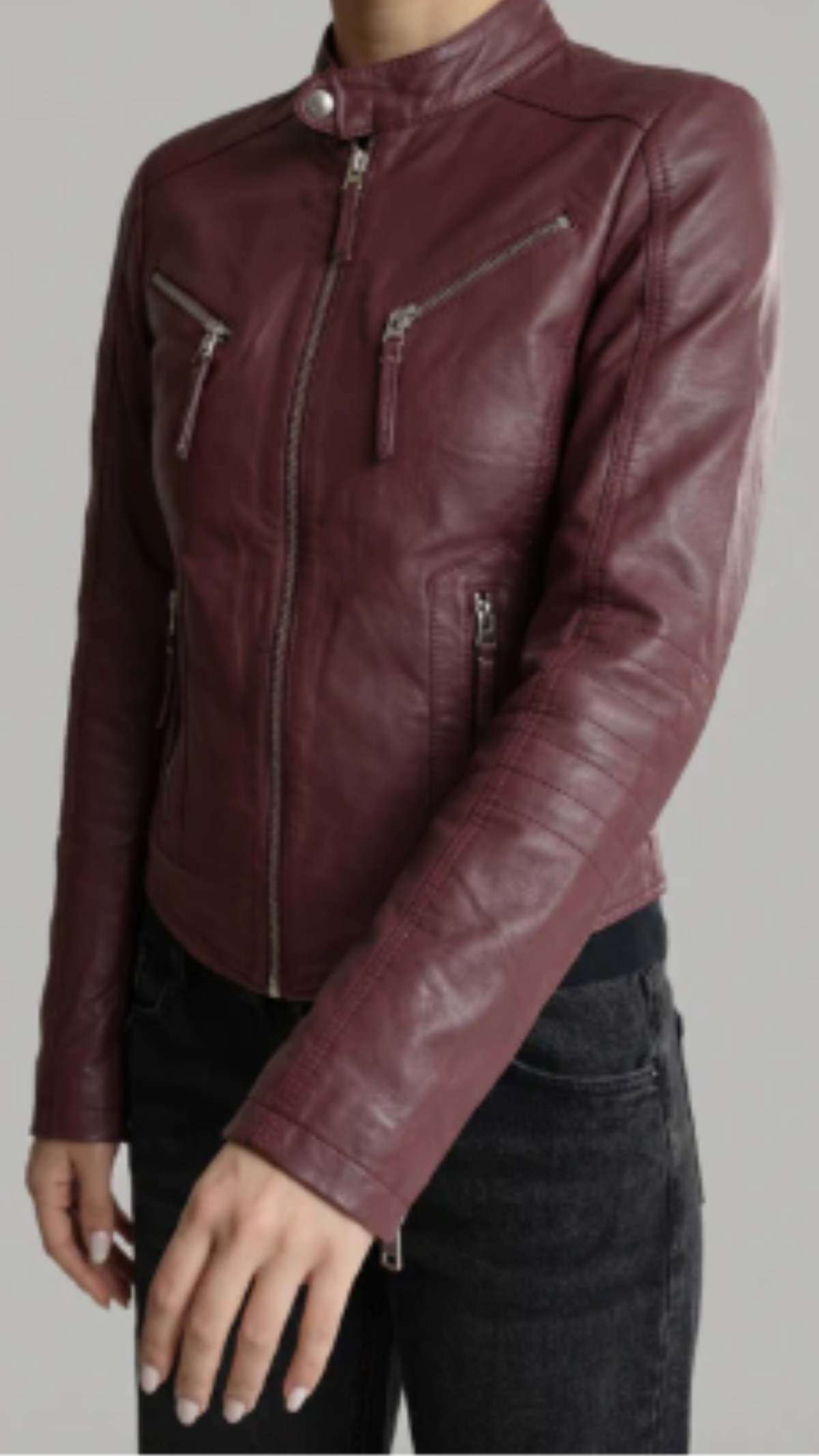 Maroon leather jacket worn by a person on a gray background