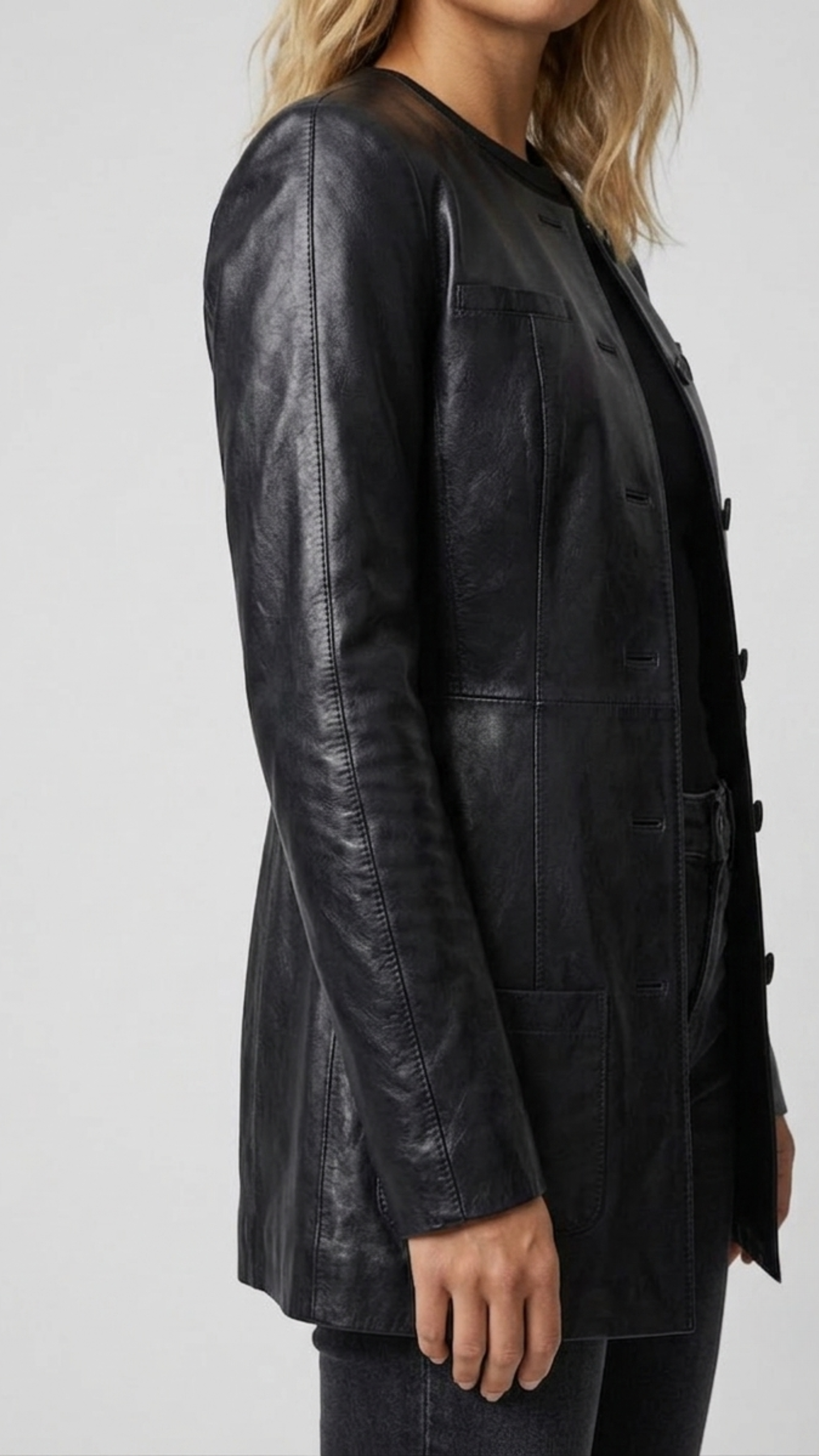 Close-up shot highlighting the premium button stitching and clean lapel design on a luxury black leather overcoat.
