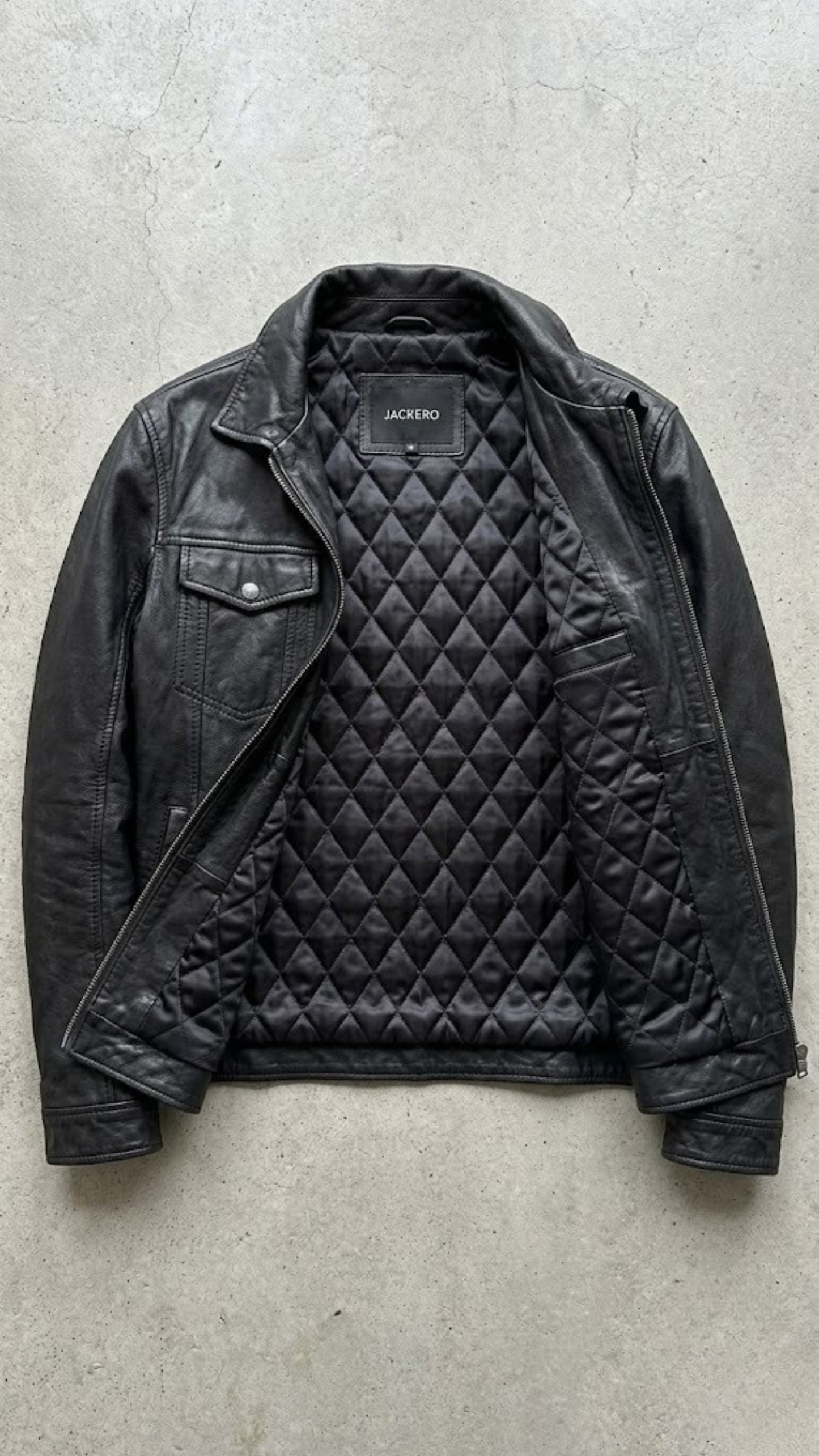 Detailed shot showcasing the point collar design, premium metallic buttons, and high-quality cuff details of a black leather trucker coat.