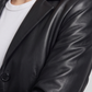 Close-up shot highlighting the soft, buttery texture of premium black leather and precise stitching on a ladies' suit jacket.