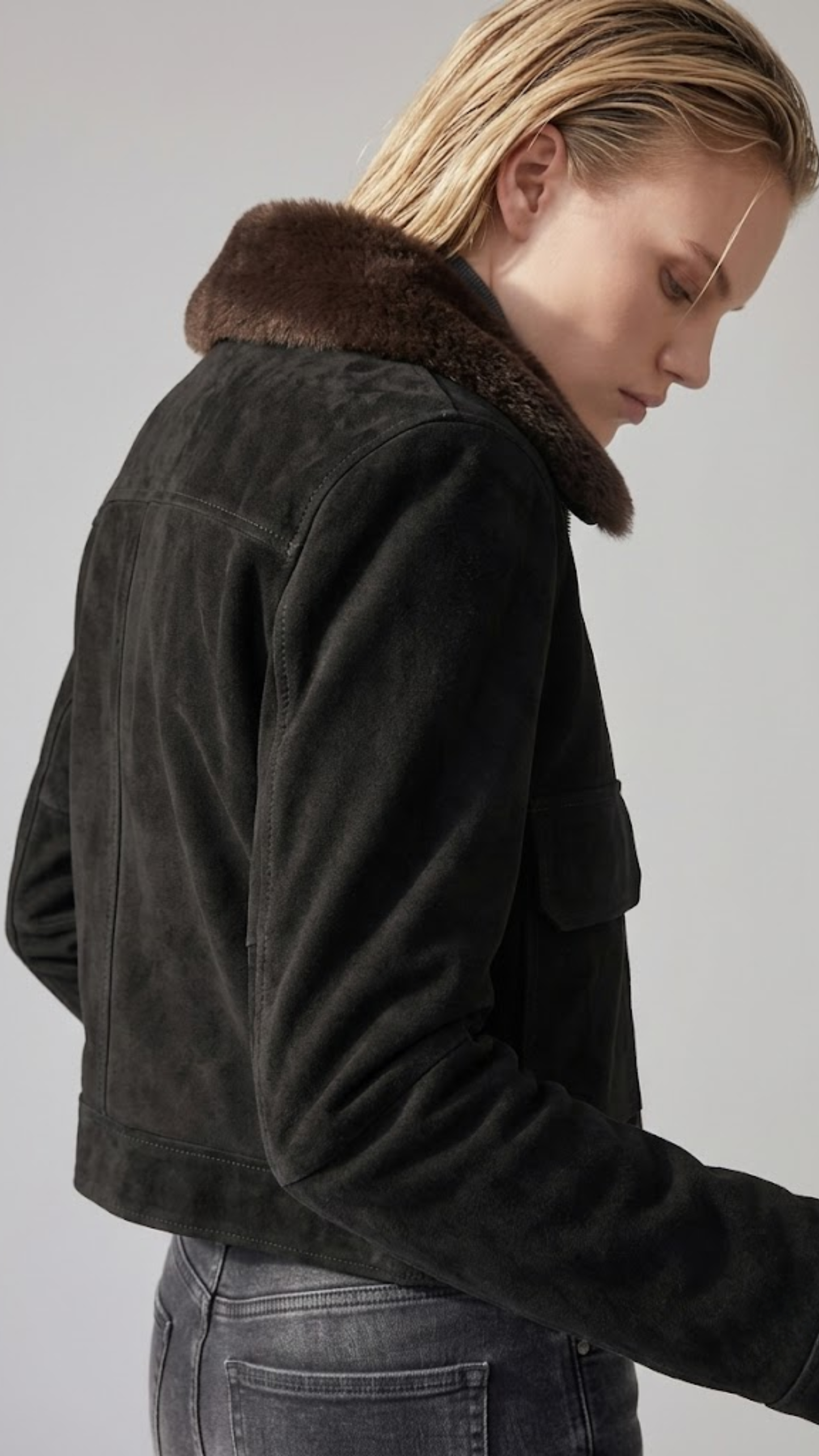 Close-up shot highlighting the velvet-soft matte finish of jet-black suede fabric contrasted with the plush dark chocolate brown faux shearling inner lining.