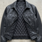 Premium dark black genuine leather bomber jacket by JACKERO displayed in professional studio lighting for an e-commerce catalog.