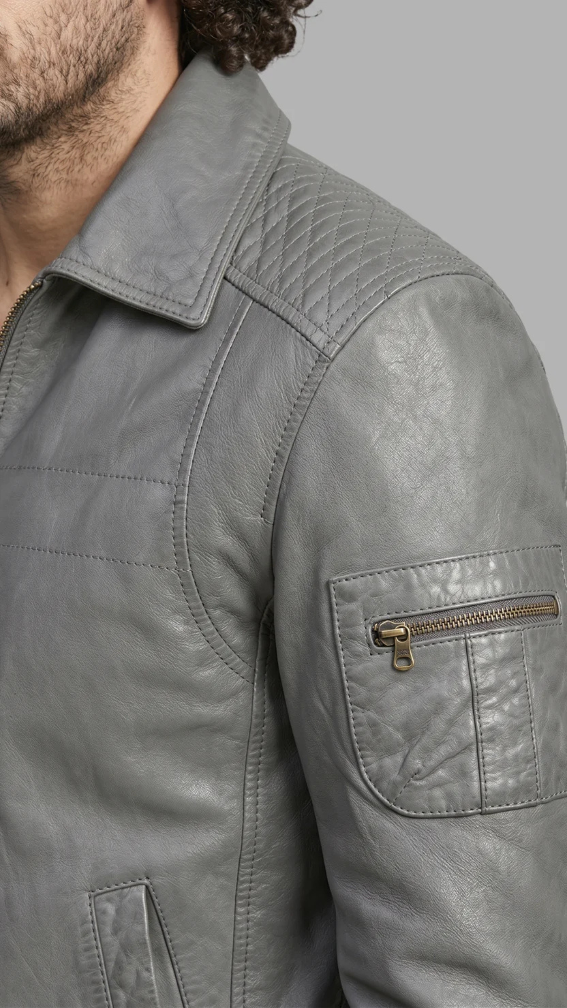 Gray jacket with a pocket and zipper on a neutral background