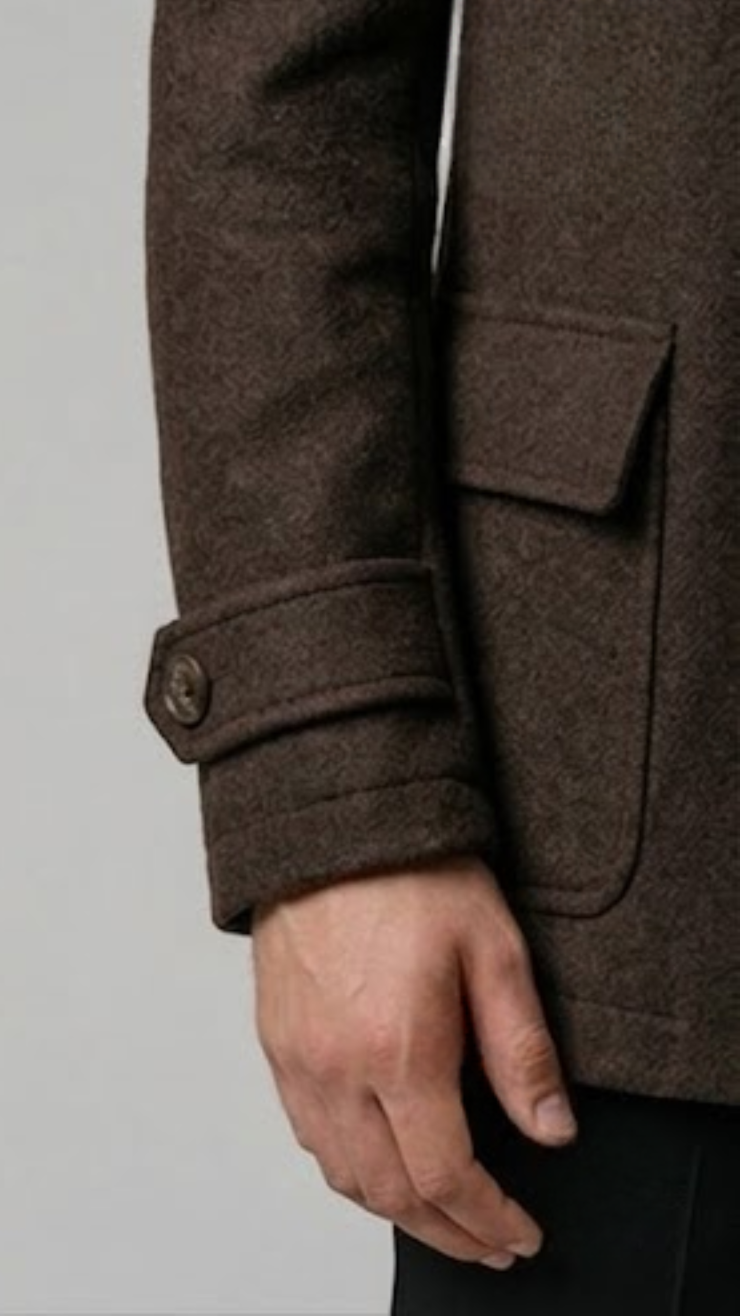 Close-up shot highlighting the rich, thick texture of premium espresso brown wool fabric and fine lapel stitching.