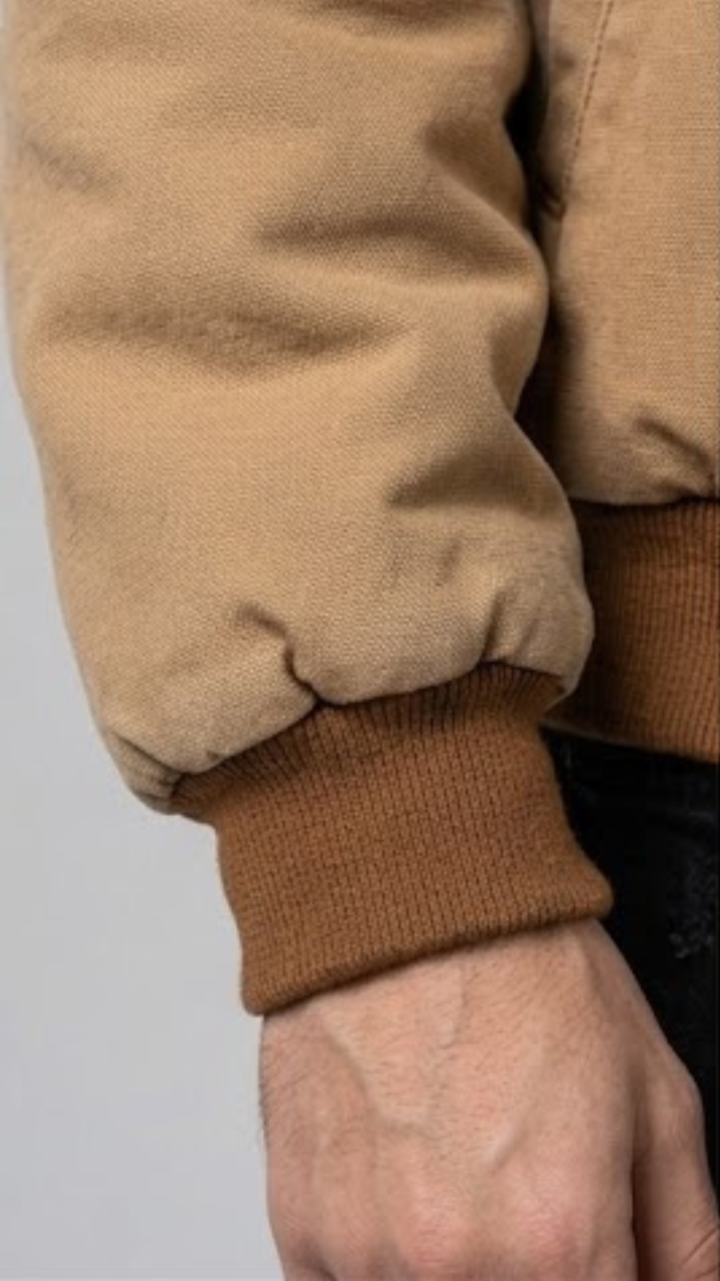 Close-up shot highlighting the ultra-soft weave texture and high-quality stitching on a premium tan brown cotton jacket.