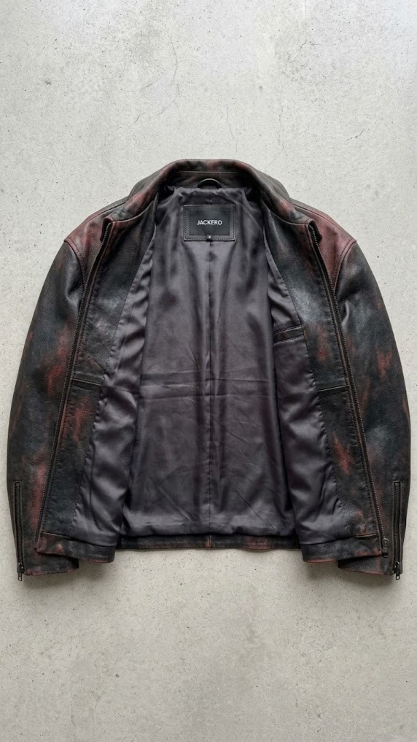 Clean jackero jacket catalog flat lay of a premium black leather button-down trucker outerwear on a solid grey backdrop.