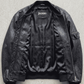 Authentic Jackero brand premium black leather bomber jacket displayed on a solid studio background, emphasizing athletic luxury craftsmanship.
