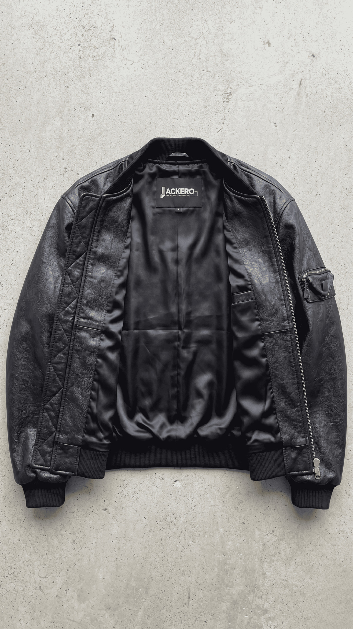 Authentic Jackero brand premium black leather bomber jacket displayed on a solid studio background, emphasizing athletic luxury craftsmanship.