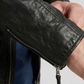 Close-up shot highlighting the smooth, premium texture of genuine black leather and high-quality metallic hardware.