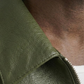 Close-up of a green leather jacket with a zipper
