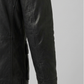 Close-up shot showing the rugged texture of high-quality black leather paired with durable metallic snap buttons on a field coat pocket.