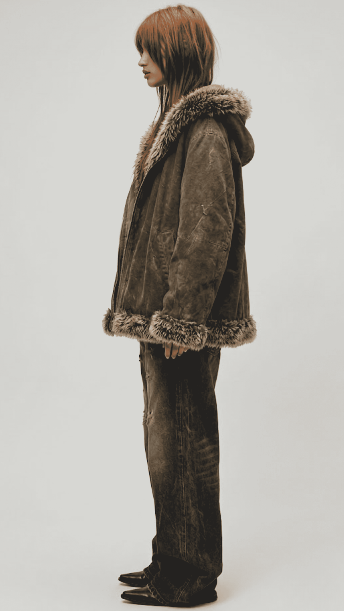 Side profile view displaying the comfortable slouchy baggy silhouette and broad shoulder drop of a dark olive green suede jacket.
