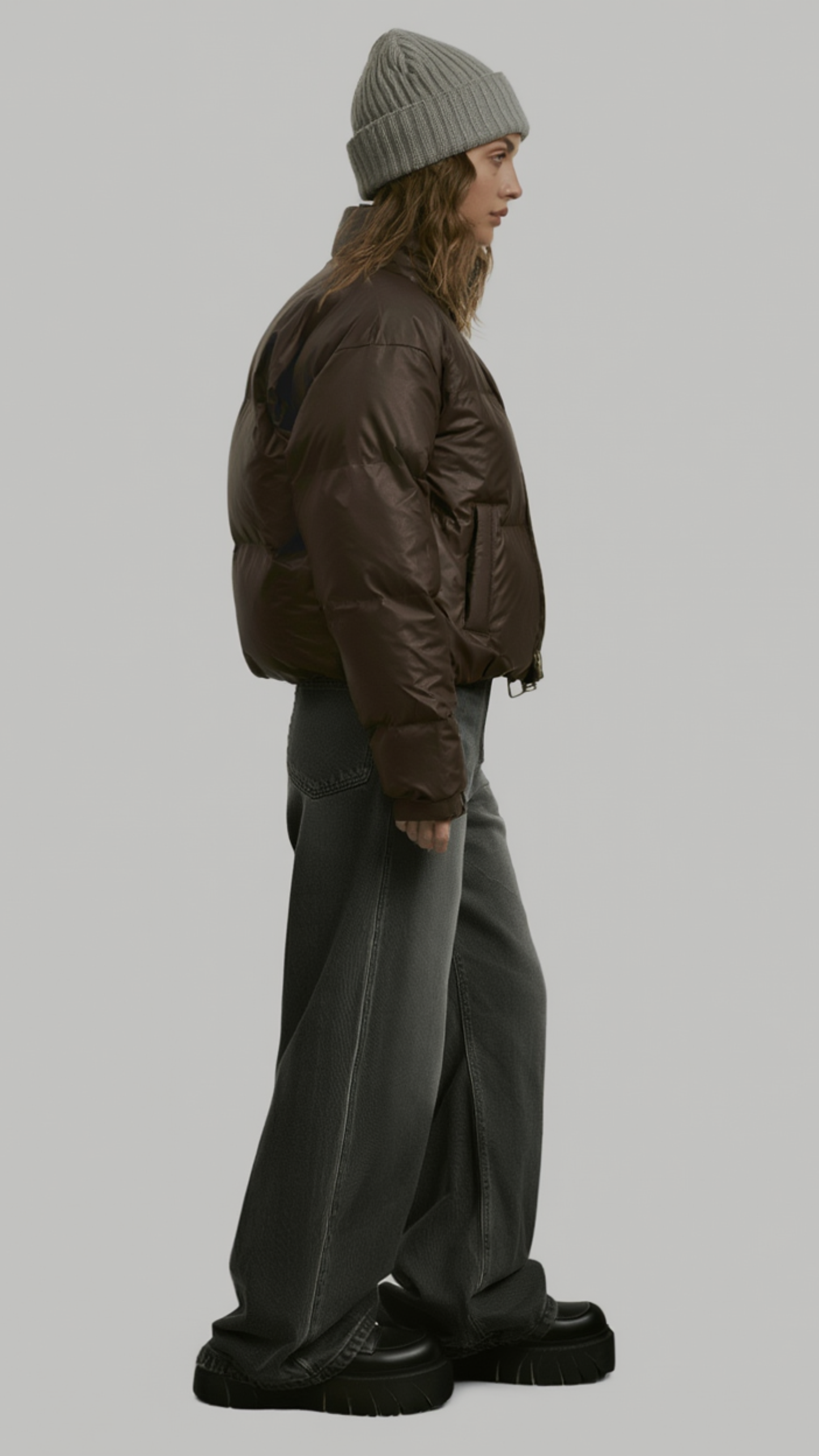a modern chocolate brown streetwear puffer jacket styled with minimalist winter apparel.