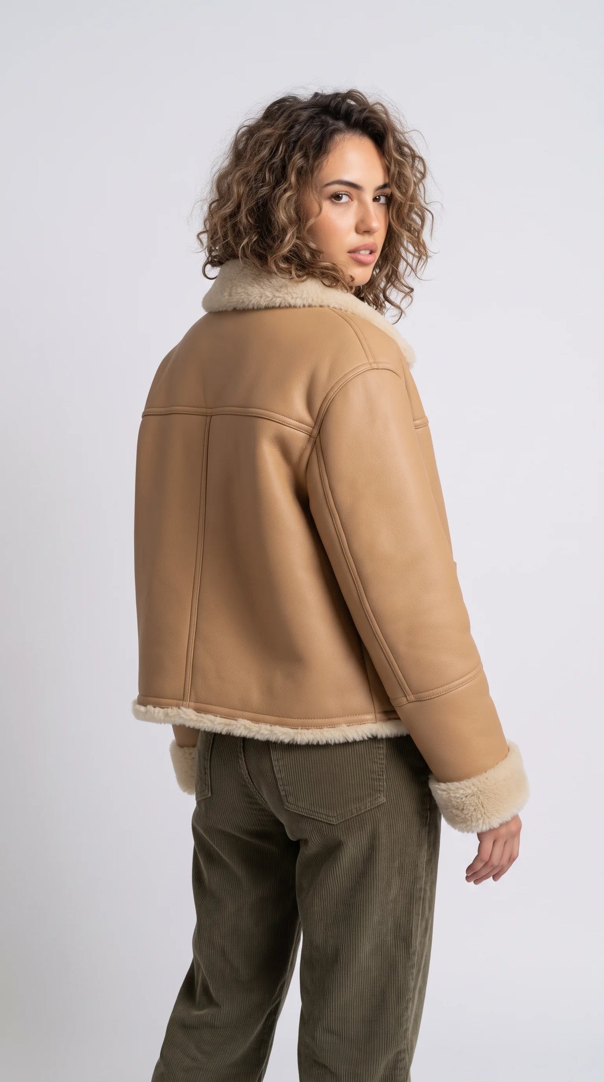 JACKERO beige leather shearling jacket features a contemporary short car coat silhouette, soft cream trim, structured patch pockets and a relaxed boxy fit for premium winter styling.