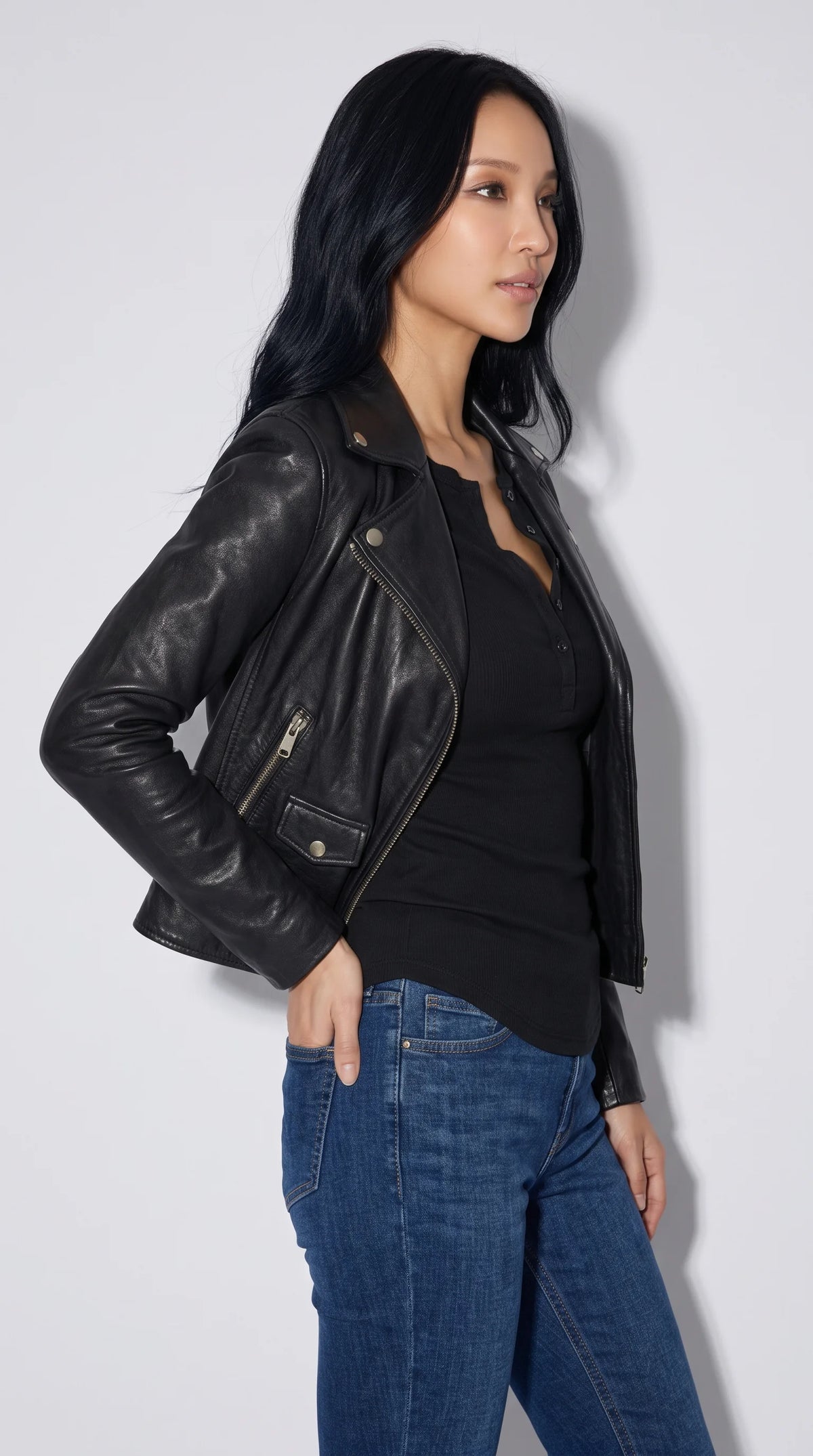 JACKERO black genuine leather moto jacket with metal zip pockets, zip-fastened sleeve cuffs, reinforced panel stitching and a structured shoulder line, combining functional hardware with a sharp contemporary silhouette for confident streetwear styling.