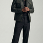 Model wearing a classic black leather trucker jacket with cream collar, styled with vintage blue jeans.