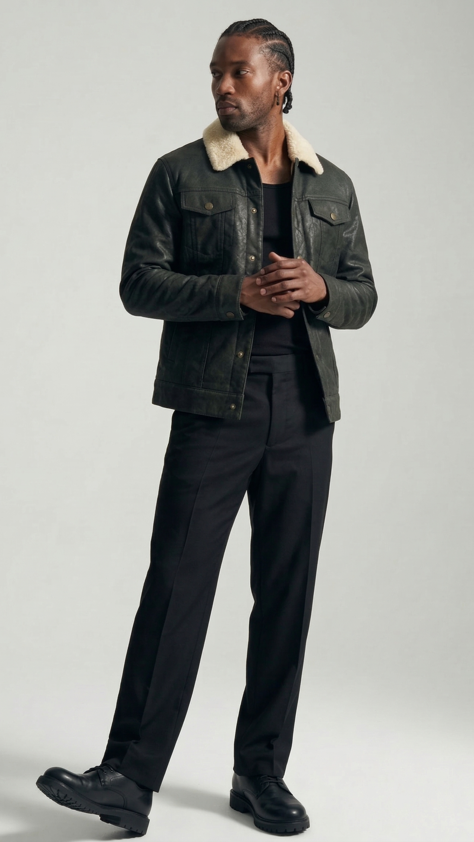 Model wearing a classic black leather trucker jacket with cream collar, styled with vintage blue jeans.