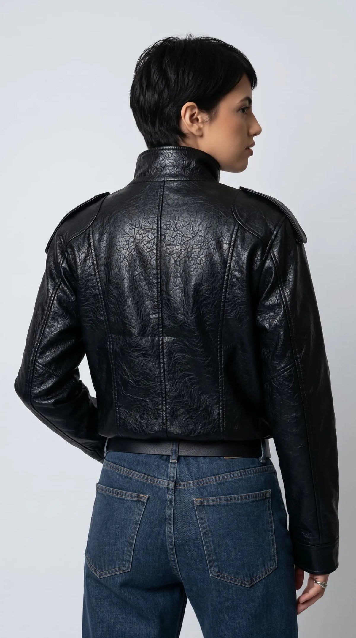 JACKERO black textured leather oversized jacket highlighting its shoulder epaulettes, carefully stitched leather panels, smooth sleeve cuffs and asymmetrical front fastening for a distinctive designer-inspired outerwear look.