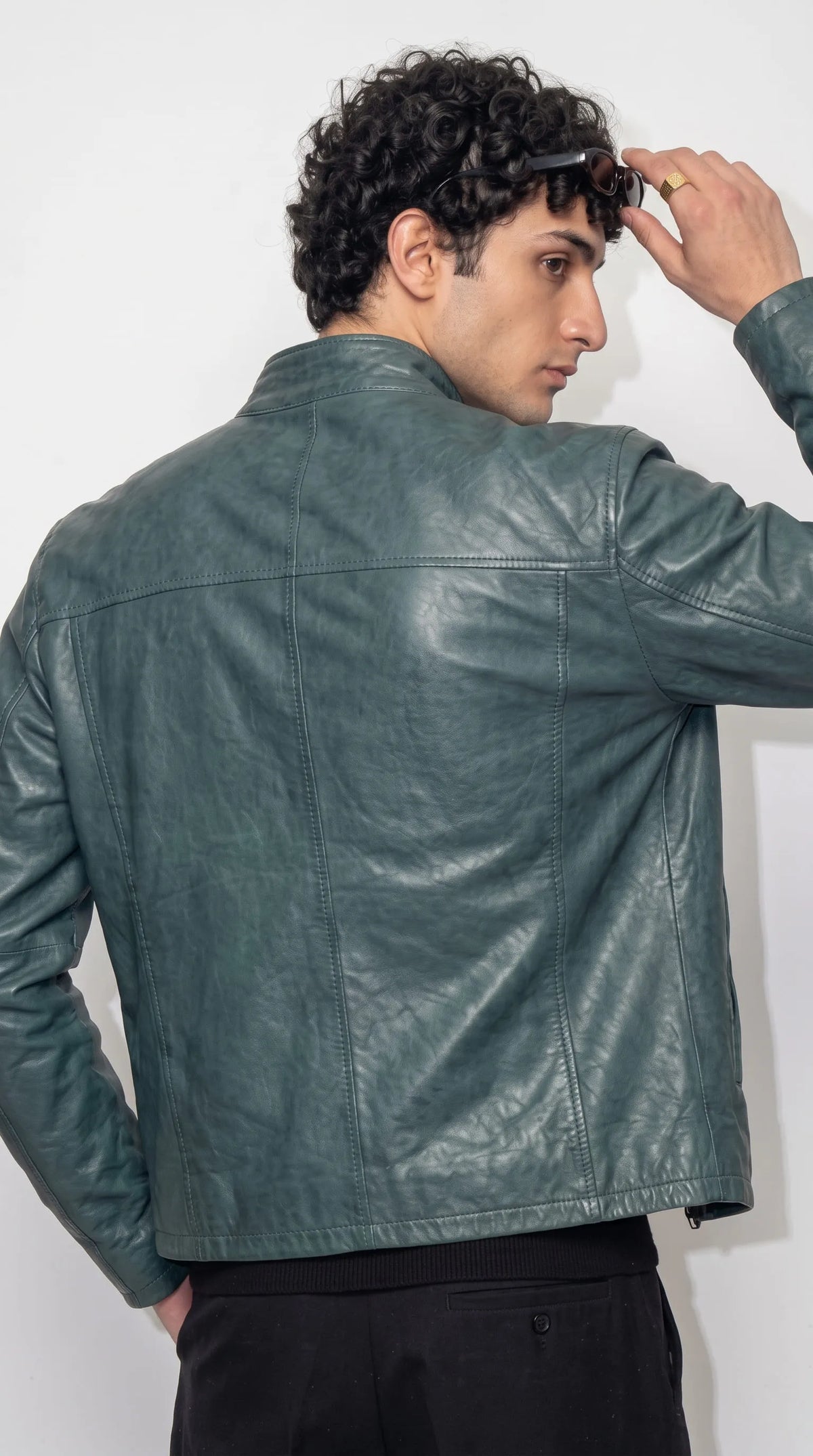JACKERO dark cyan genuine leather jacket showcasing a defined shoulder yoke, vertical stitched panels, natural leather creases and a smooth semi-matte petrol-blue finish for a refined contemporary outerwear aesthetic.