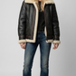 Premium black leather jacket with a distinct faux cream shearling collar by Jackero, professional front view catalog shot.