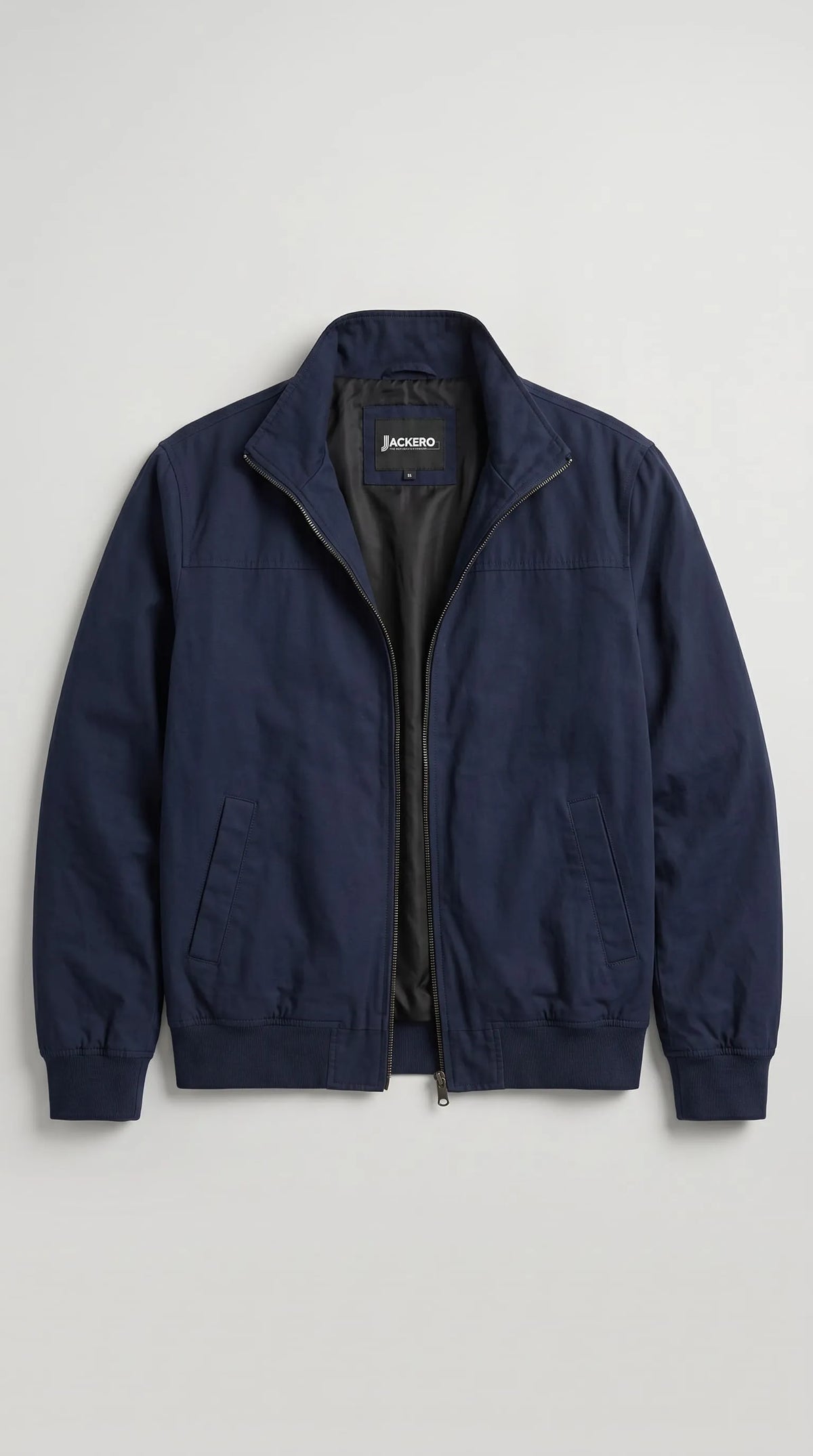 JACKERO dark navy blue cotton jacket displayed open to reveal its smooth black inner lining, branded neck label and full-length metal zipper. The clean interior finish, raised collar, neatly stitched panels and angled side waist pockets showcase the practical construction of this men’s zip-up jacket, designed for versatile everyday wear and polished casual layering.