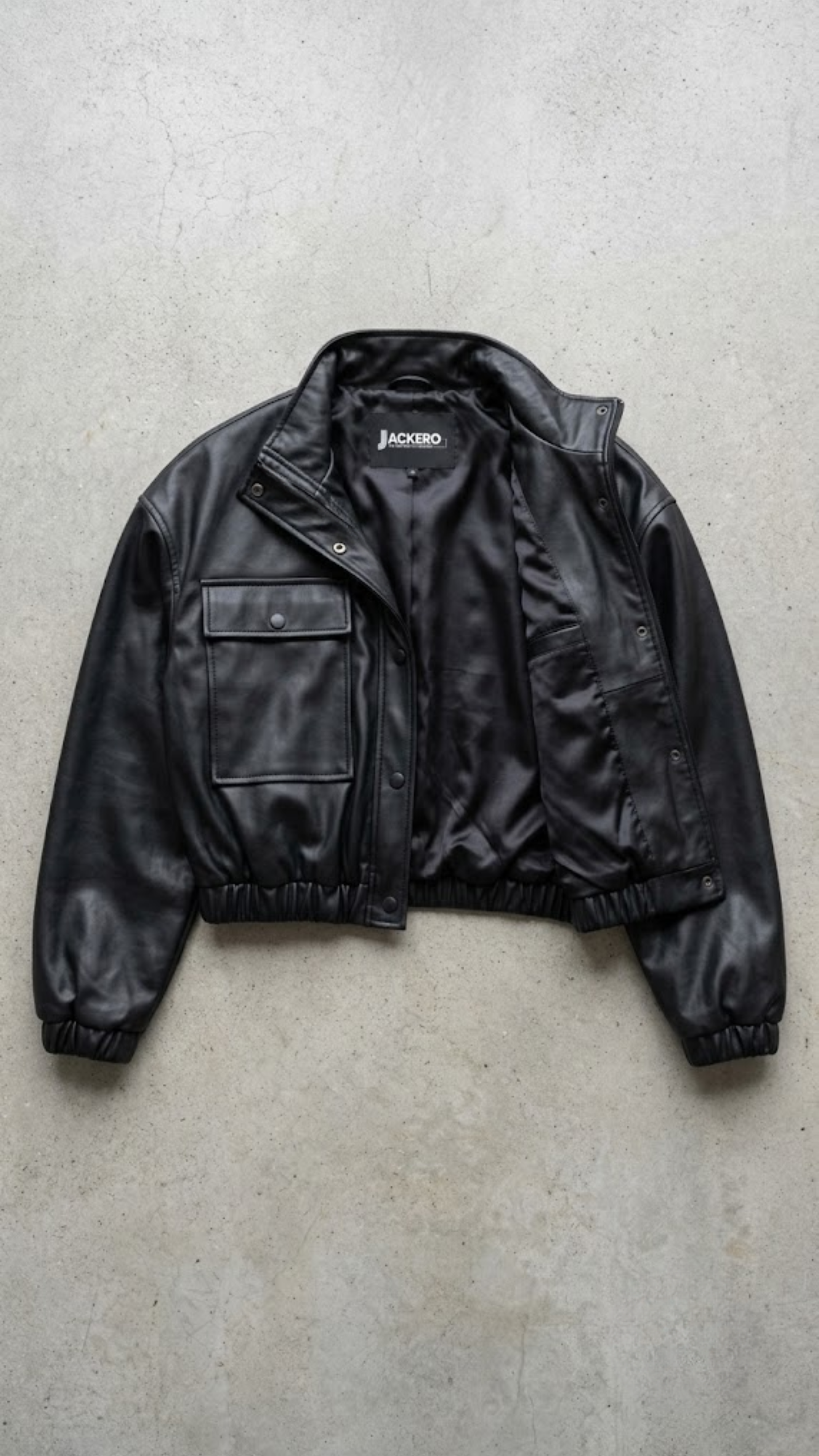Jackero contemporary black leather cropped jacket beautifully presented against a clean, minimalist studio backdrop.