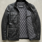 Jackero black leather field jacket with multi-pocket design beautifully presented against a clean, minimalist studio backdrop.