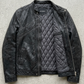 Jackero classic black leather jacket flawlessly presented against a clean, minimalist studio backdrop.