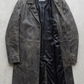 Jackero dark grey distressed leather overcoat beautifully presented against a clean, minimalist studio backdrop.