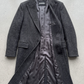 Jackero dark grey wool overcoat beautifully presented against a clean, minimalist studio backdrop.