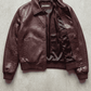 Jackero luxury dark red vine crocodile embossed leather jacket beautifully presented against a clean, minimalist studio backdrop.