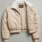 Jackero contemporary light beige silk cotton blend cropped jacket beautifully presented against a clean, minimalist studio backdrop.
