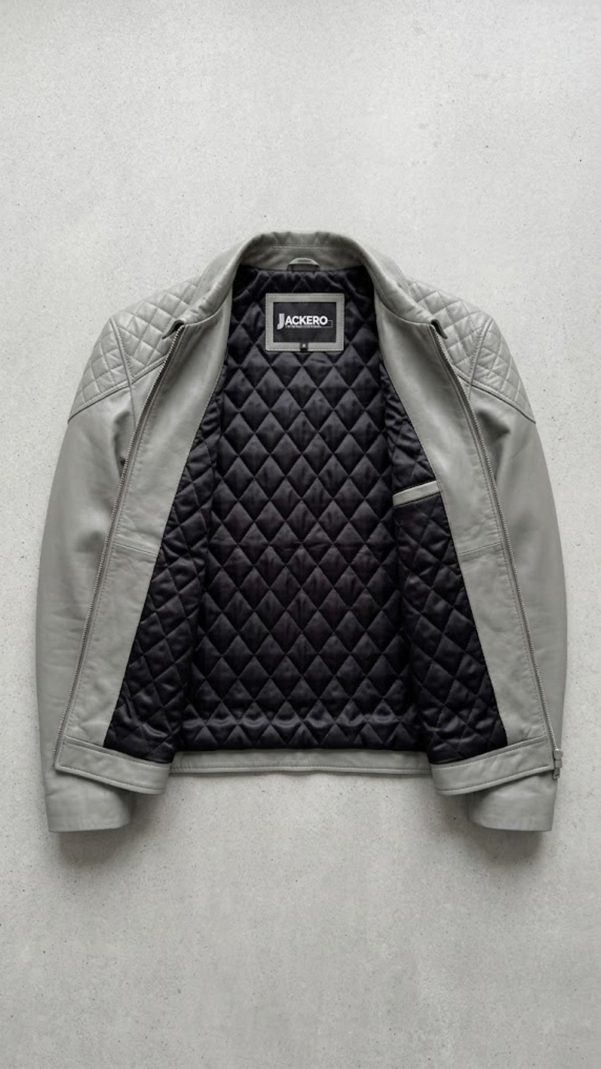 Jackero contemporary men's grey leather jacket beautifully presented against a clean, minimalist studio backdrop.