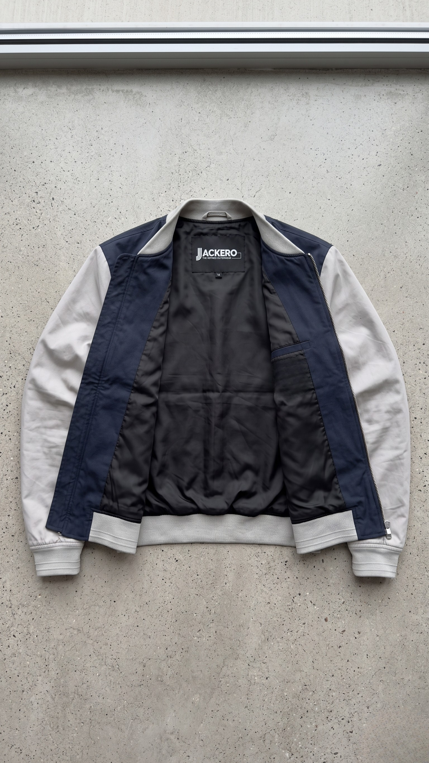 Jackero dark navy blue and grey two-tone cotton jacket perfectly presented against a minimal studio background.