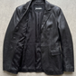 Jackero contemporary women's black leather blazer jacket beautifully presented against a clean, minimalist studio backdrop.