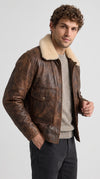 Embrace the ultimate grunge streetwear aesthetic with the Jackero distressed dark brown leather flight jacket, featuring a weathered finish and striking cream shearling for a rebellious winter look.