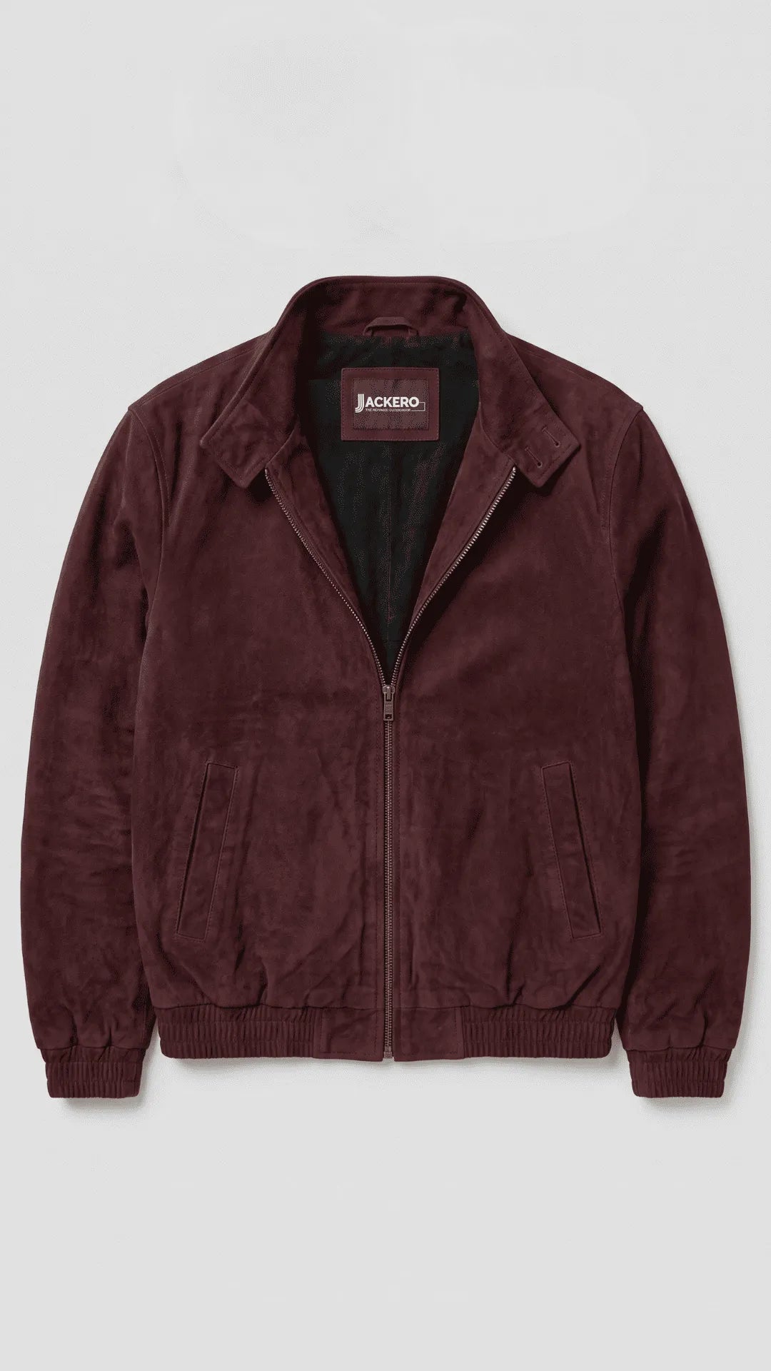 JACKERO dark wine-red cotton bomber jacket styled with an oatmeal knit sweater, charcoal washed jeans and white sneakers, combining a rich burgundy color palette with a relaxed silhouette for refined urban casual wear.
