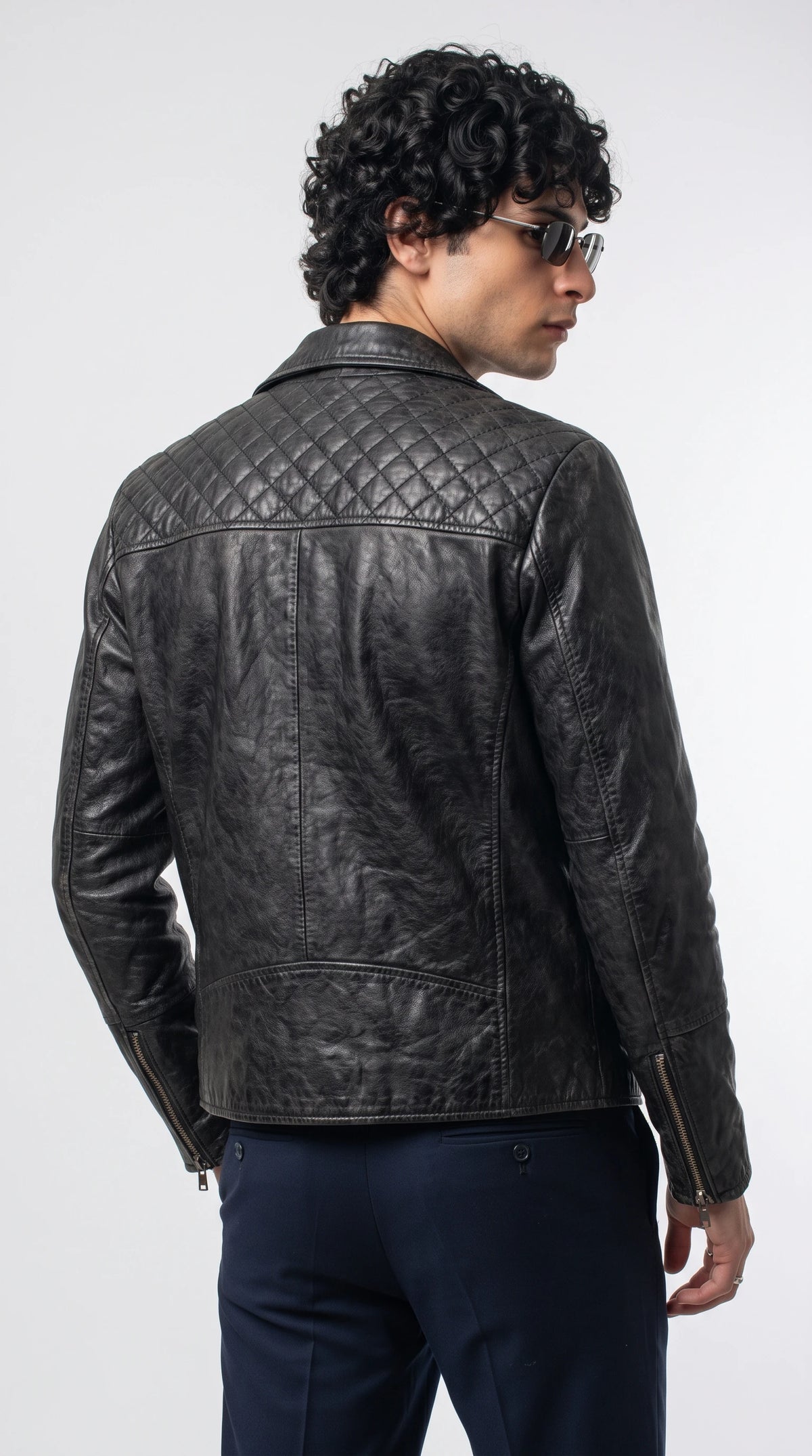 Jet-black genuine leather rider jacket featuring a diamond-quilted shoulder yoke, clean vertical back-panel seams, long fitted sleeves and precise tonal stitching, creating a structured motorcycle-inspired silhouette for modern alternative fashion.