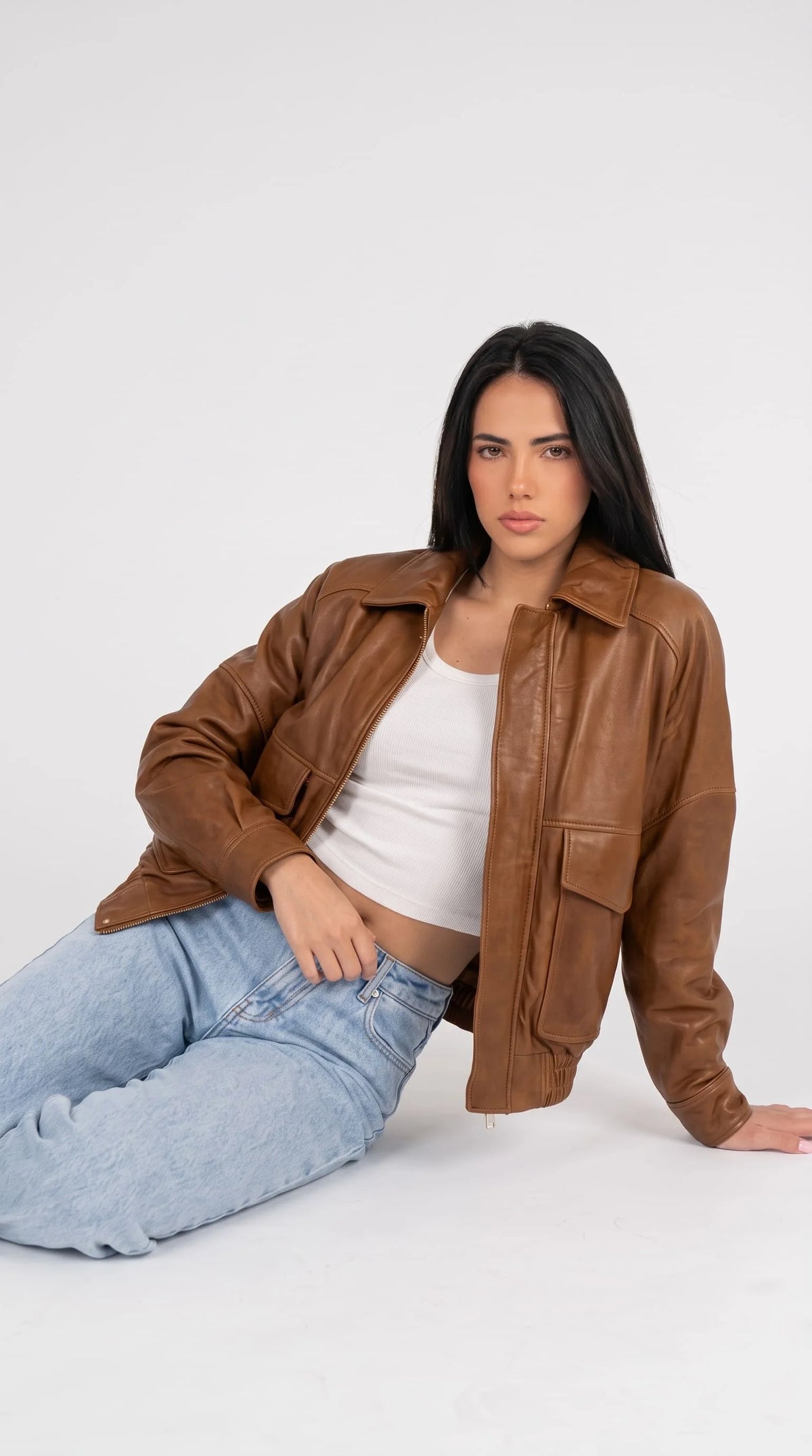 Women's relaxed fit brown leather bomber jacket, trending 2026 fashion outerwear with dropped shoulder seams, stitched panel details, flap pockets and elastic waistband, perfect for casual and street style